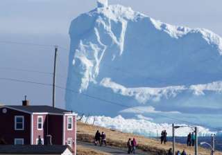 A 150-feet iceberg floats past Canadian village -... A 150-feet iceberg floats past Canadian village -...