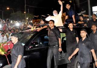 PM Modi waves at people during a road show in... PM Modi waves at people during a road show in...