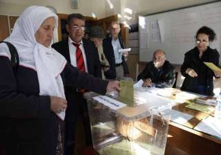 A woman casts a ballot inside a polling station... A woman casts a ballot inside a polling station...