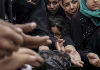 Mosul residents reach out for baked cookies at a... Mosul residents reach out for baked cookies at a...