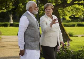Angela Merkel and Narendra Modi walk through the... Angela Merkel and Narendra Modi walk through the...