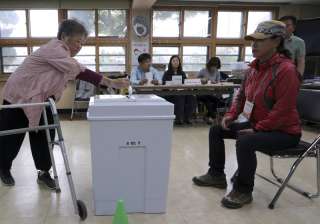 A woman casts her ballot for presidential... A woman casts her ballot for presidential...