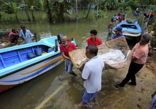 Lankan flood victims carry a woman as she is... Lankan flood victims carry a woman as she is...