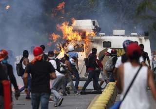 Anti-govt protesters set fire to an armored... Anti-govt protesters set fire to an armored...