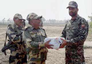 Jammu: BSF personnel exchange sweets with a... Jammu: BSF personnel exchange sweets with a...
