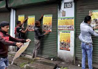 GJM activists paste party posters during... GJM activists paste party posters during...