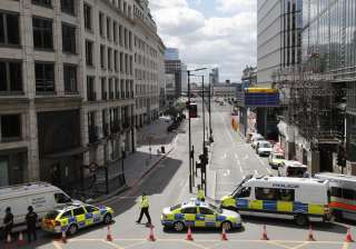 Police vans block access to a street after an... Police vans block access to a street after an...