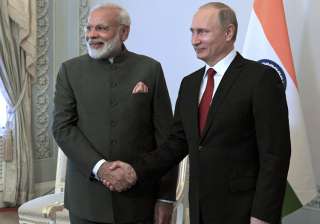 Putin shakes hands with Modi at the St.... Putin shakes hands with Modi at the St....