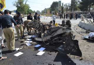 Pakistani police officers examine the site of an... Pakistani police officers examine the site of an...
