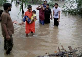 People wade through floodwaters after heavy... People wade through floodwaters after heavy...