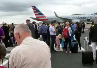 Passengers stand on the tarmac after being... Passengers stand on the tarmac after being...
