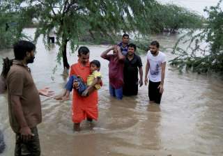 People wade through floodwaters after heavy... People wade through floodwaters after heavy...