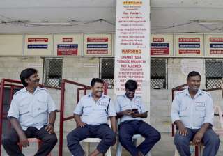 Guards sitting near the ticket counter of a... Guards sitting near the ticket counter of a...