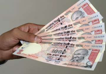 File pic - A man displays scrapped Rs 1,000 notes... File pic - A man displays scrapped Rs 1,000 notes...