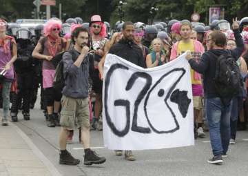 Protestors hold posters on the first day of G20... Protestors hold posters on the first day of G20...