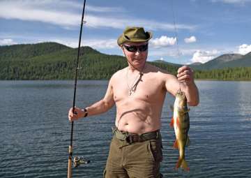 Putin holds a fish he caught during a mini-break... Putin holds a fish he caught during a mini-break...