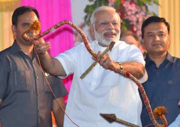 PM Modi holds a bows and arrow during Dussehra... PM Modi holds a bows and arrow during Dussehra...