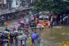 People wade through a waterlogged street following heavy