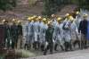 Rescuers walk toward the entrance to a cave complex where
