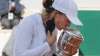 Poland's Iga Swiatek kisses the trophy after winning the